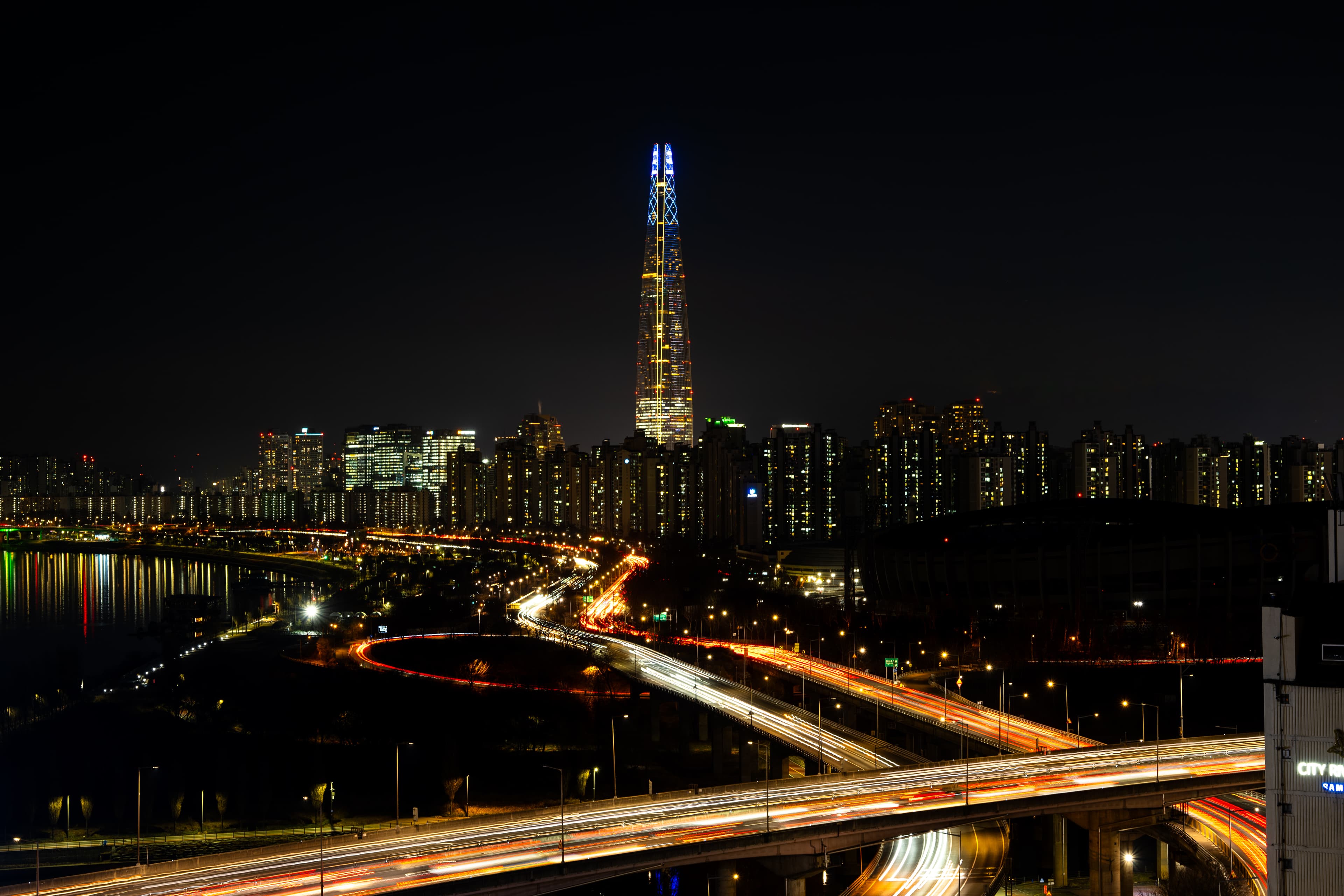 Night cityscape with light trails and tower